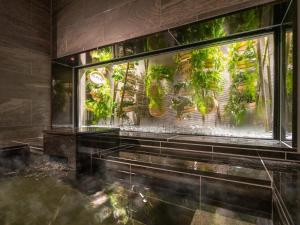 a room with a window filled with lots of plants at Super Hotel Beppu Ekimae in Beppu