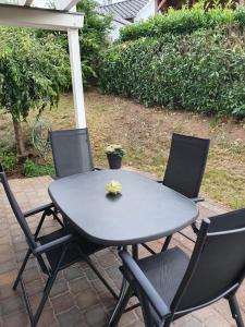 une table et quatre chaises sur la terrasse dans l'établissement Katjas Ferienwohnung, à Nittel