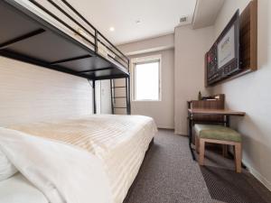 a bedroom with a bunk bed and a desk at Super Hotel Beppu Ekimae in Beppu