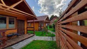 a backyard with a wooden fence and a patio at Domki u Stasi in Stegna