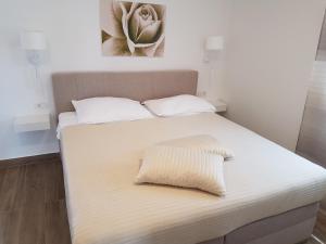 a white bed with a pillow on top of it at Villa Jeka, Malinska, Krk in Malinska