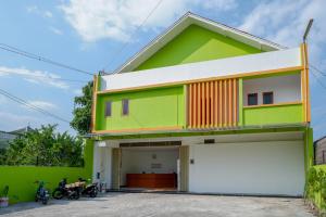 een kleurrijk huis met een garage bij RedDoorz @ Jalan Wonosari KM.9 in Yogyakarta