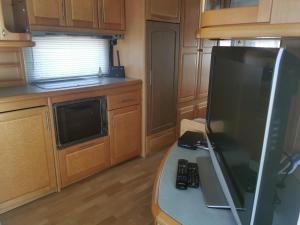 a kitchen with a counter with a tv and a microwave at Sea Caravan/Camper on the Beach in Kiten