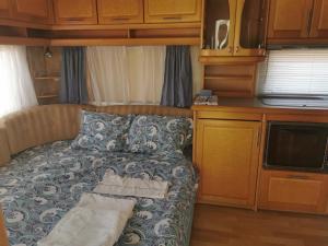 a small bedroom with a bed in an rv at Sea Caravan/Camper on the Beach in Kiten