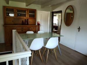 a dining room with a glass table and white chairs at Ferienwohnung Hamm Rhynern im alten Bauernhaus 1870 in Hamm +11 photos