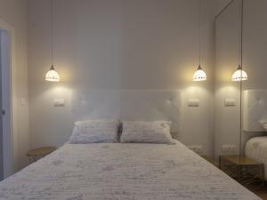 a bedroom with a white bed with two pillows at RD APARCAMIENTO INCLUIDO TRIANA luminoso cómodo apartamento 2Bd 2Bth in Seville