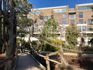 people walking on a boardwalk in front of a building at Panoramic Park And City Penthouses Retreat in London