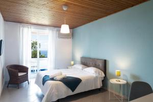 a bedroom with a bed and a large window at Paradise Relais Villa Janto' in Ischia