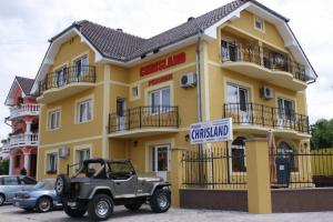 a jeep parked in front of a yellow building at Pensiunea Chrisland in Oradea