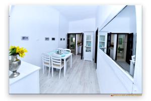 a white kitchen with a table and a dining room at Casa Fotografului in Constanţa