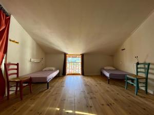 a room with two beds and chairs in a attic at Gite de la Porte Saint Jacques: a hostel for pilgrims in Saint-Jean-Pied-de-Port