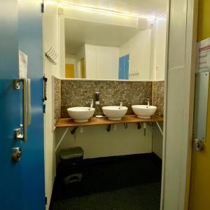 a bathroom with three sinks and a mirror at Gite de la Porte Saint Jacques: a hostel for pilgrims in Saint-Jean-Pied-de-Port