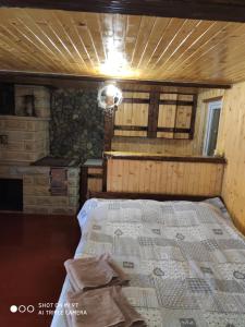 ein Schlafzimmer mit einem Bett in einem Holzzimmer in der Unterkunft Чан-садиба Гуцульська пісня in Mykulytschyn