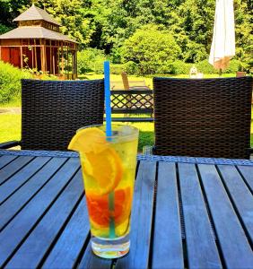 a drink with a blue straw sitting on a wooden table at Pałac Bażantarnia in Pszczyna
