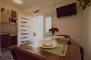 una mesa de comedor con un plato y flores. en Holiday Home Željko,Marija & Jakov, en Starigrad-Paklenica