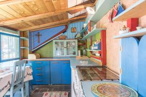 a kitchen with blue cabinets and a cross on the wall at Casa Jasmina in Dro