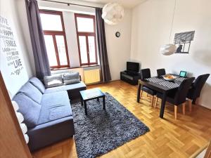 a living room with a blue couch and a table at Gozsdu Apartment in Budapest