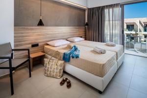 a bedroom with a bed and a desk and a chair at ONEIRO Boutique Hotel in Tigaki