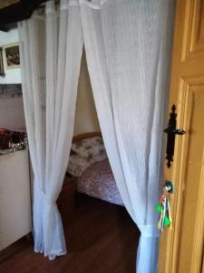 a bed with white curtains in a room at Boomerang Cottage B&B in Quintanapalla