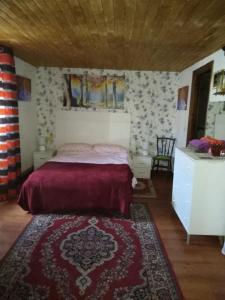 Schlafzimmer mit einem Bett mit einer roten Tagesdecke in der Unterkunft Boomerang Cottage B&B in Quintanapalla