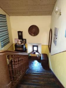 Boomerang Cottage B&B في Quintanapalla: غرفة بها درج مع أريكة وساعة
