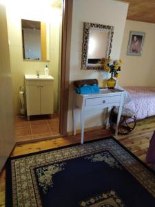 Zimmer mit einem Bett, einem Tisch und einem Spiegel in der Unterkunft Boomerang Cottage B&B in Quintanapalla