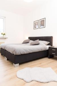 a bed in a bedroom with a black bed frame at - NEU - Große & gemütliche 3 Zimmer Wohnung in Neulsenburg