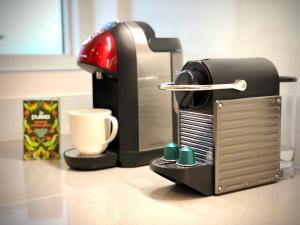 a coffee machine sitting on a counter with a cup at Panoramic Park And City Penthouses Retreat in London