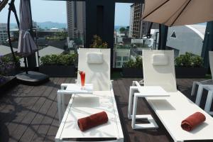dwa białe stoły i krzesła na balkonie w obiekcie Empress Pattaya Hotel w mieście Pattaya Central