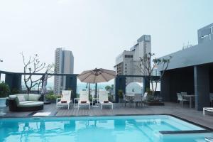 basen na dachu budynku z krzesłami i parasolem w obiekcie Empress Pattaya Hotel w mieście Pattaya Central