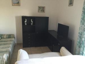 salon z czarną komodą i telewizorem w obiekcie Casa Rosa w mieście Porto SantʼElpidio