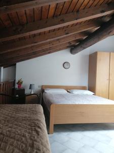 um quarto com 2 camas e um tecto de madeira em Casa vacanze 'La piazza' em Zone
