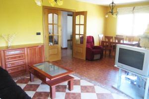 een woonkamer met een flatscreen-tv en een tafel bij Casa rural a 20 minutos de la Alhambra in Granada