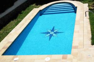 una piscina blu con un orologio al centro di Casa rural a 20 minutos de la Alhambra a Granada
