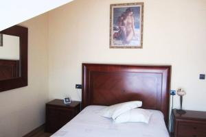 ein Schlafzimmer mit einem Bett und einem Gemälde an der Wand in der Unterkunft Casa rural a 20 minutos de la Alhambra in Granada + 9 Fotos