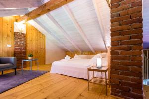 Borgo TicinoにあるRelais Dei Cesariの白いベッドとレンガの壁が備わるベッドルーム1室が備わります。