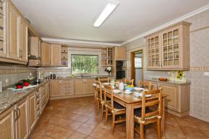 a kitchen with a wooden table and chairs in it at Villa João Paulo in Albufeira