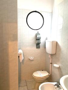 y baño con aseo, lavabo y espejo. en Hotel Ondina, en Cattolica