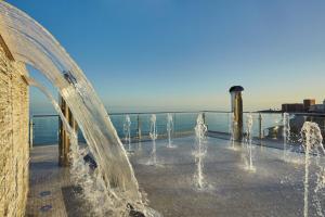 a fountain with water in front of the ocean at Hotel Las Arenas, Affiliated by Melia in Benalmádena