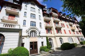 - un grand bâtiment blanc avec des portes et des fenêtres rouges dans l'établissement Résidence du Mont-Blanc n°5Bis, à Combloux