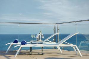 una mesa blanca y sillas en un balcón con vistas al océano en Hotel Las Arenas, Affiliated by Melia, en Benalmádena