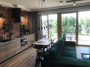 a living room with a green couch and a table at Marina Green Loft in Ełk