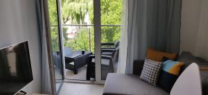 a living room with a couch and a sliding glass door at Apartamenty Hugo Centrum in Słupsk