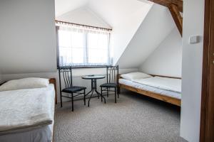 a room with two beds and a table and chairs at Penzion Zlaté Slunce in Chocenice