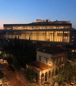 een groot gebouw met lichten aan in een stad bij Acropolitana Grand view veranda in Athene