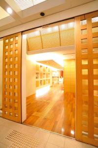 
an open door leading to a room with a wooden floor at Hotel the Lutheran in Osaka
