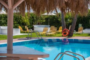 a swimming pool with chairs and an umbrella at I Candy Malia by Estia in Malia +9 photos