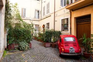 ein rotes Auto, das vor einem Gebäude parkt in der Unterkunft Boutique Grifone in Rom