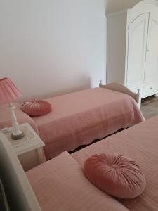 a bedroom with two beds and a table with a lamp at L'attico b&b in Cirò Marina