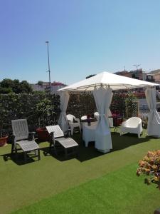 einen Pavillon mit Stühlen und Tischen auf einem Rasen in der Unterkunft B&B FLAVIO in Pozzuoli